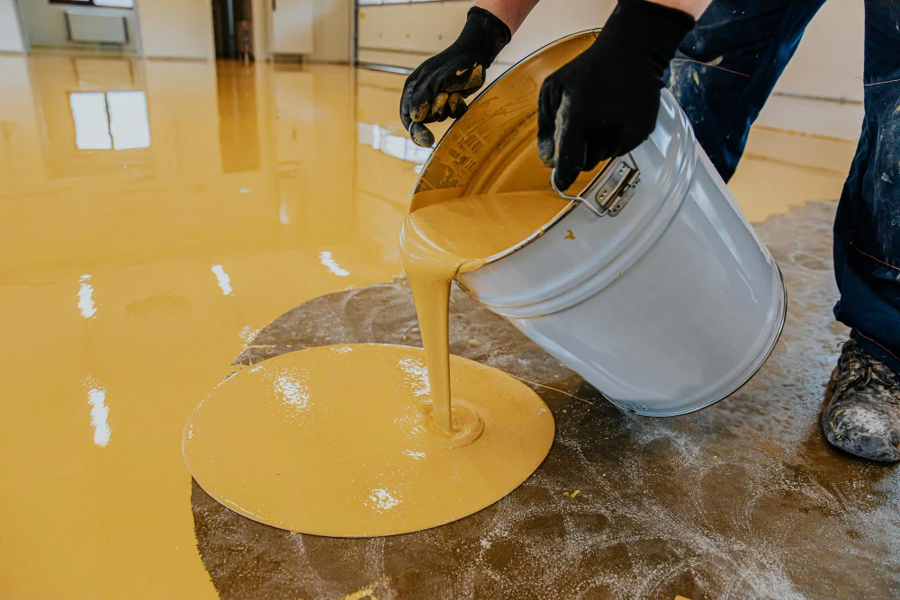 A construction worker apply epoxy resin in an industrial hall